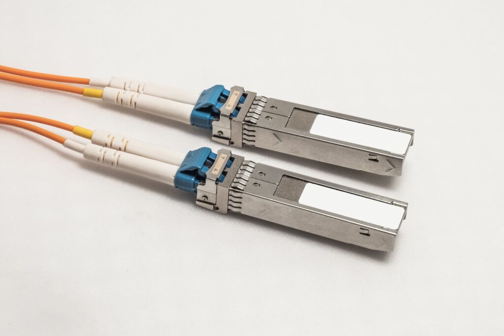 Zwei SFP-Module mit orangefarbenen Glasfaserkabeln