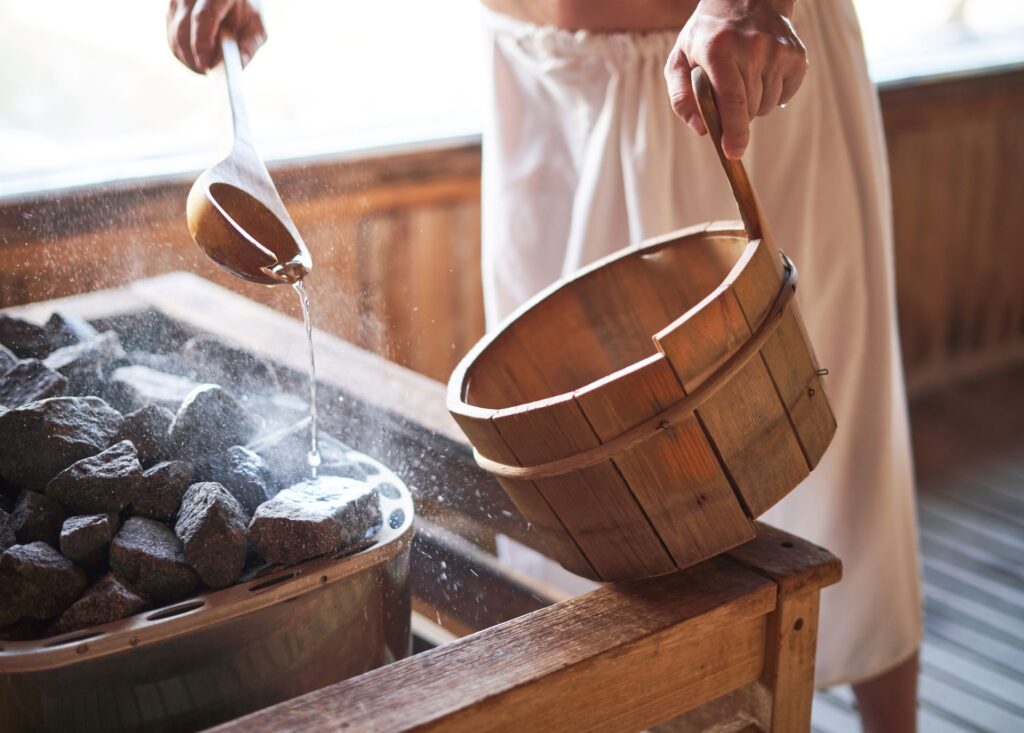 Aufguss in der Sauna mit Holzkübel.