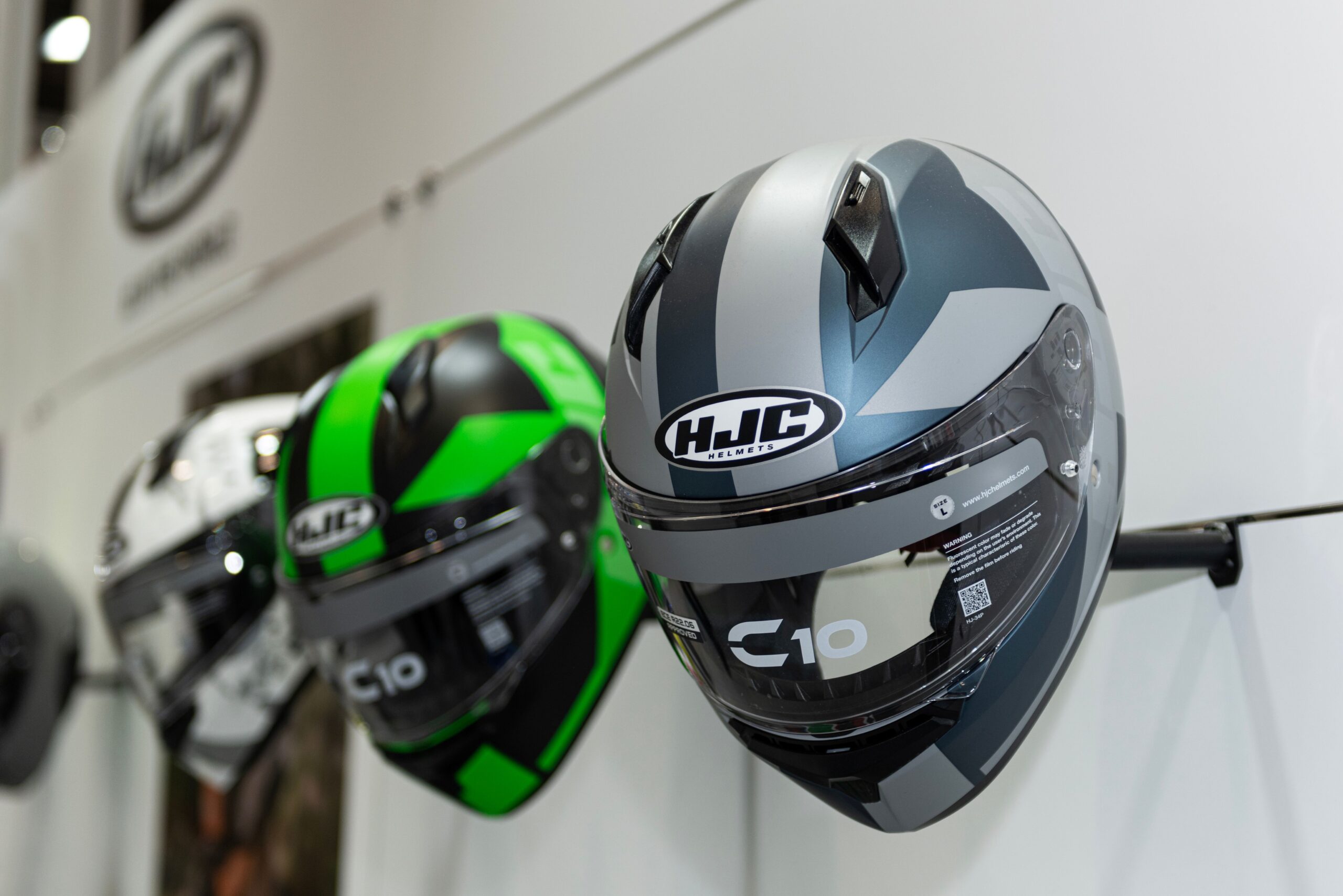HJC Helme C10 in verschiedenen Farben an Wandhalterung zur Modellwahl im Fachhandel