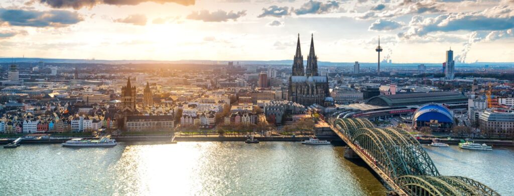 Stadtansicht von Koeln mit Koelner Dom und Rhein bei Sonnenuntergang – ideal fuer Sportmediziner Koeln, die Bewegung und Stadtleben verbinden