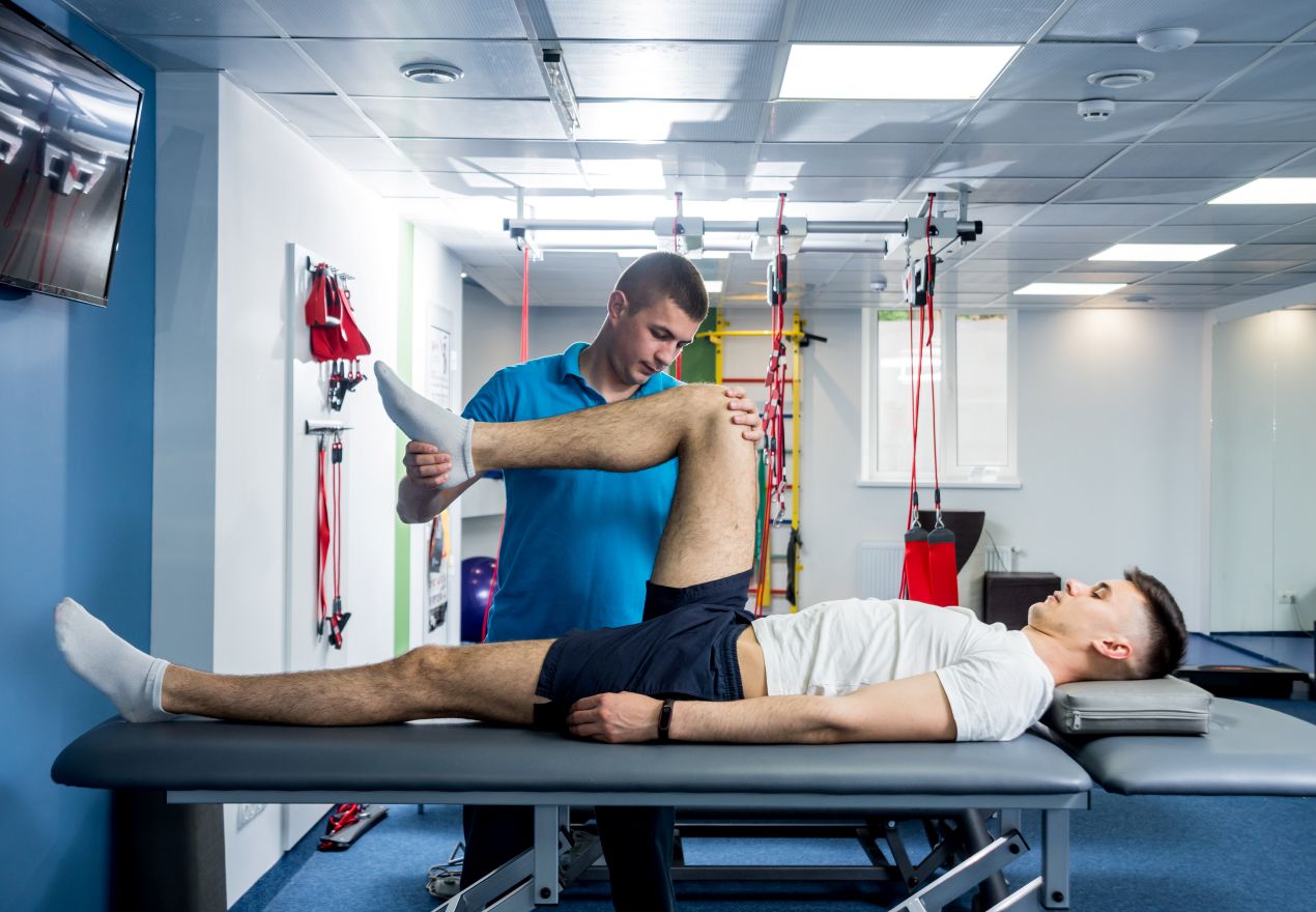 Sportler bei physiotherapeutischer Behandlung in Trainingsraum – professioneller Ansatz fuer Sportmediziner Koeln mit Fokus auf Reha und Praevention
