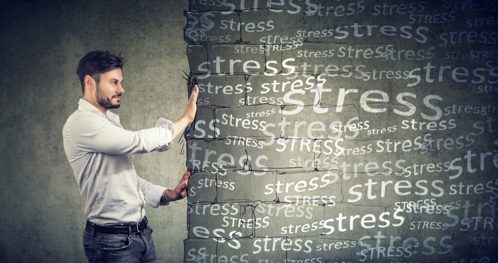 Mann stemmt Wand mit Wort Stress als Symbol für innere Stärke | Elf Bar Elfa